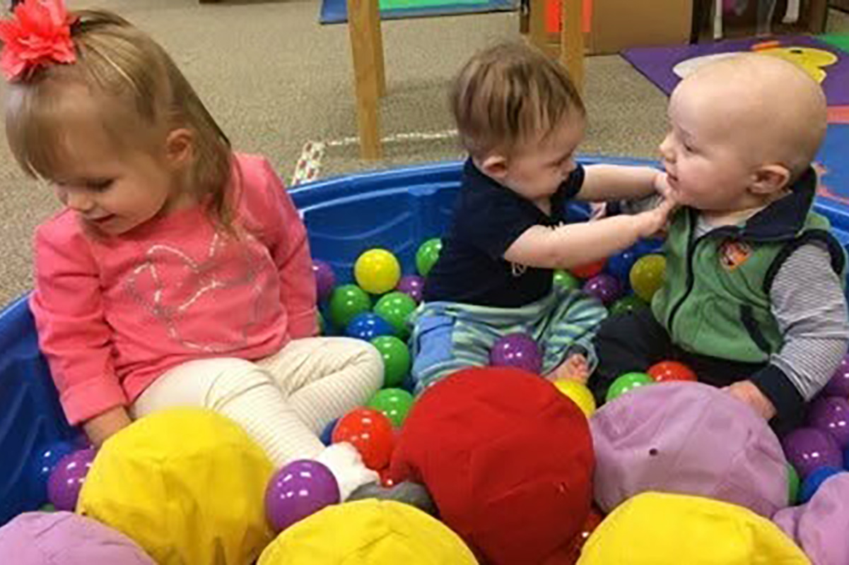 three babies in ball pit